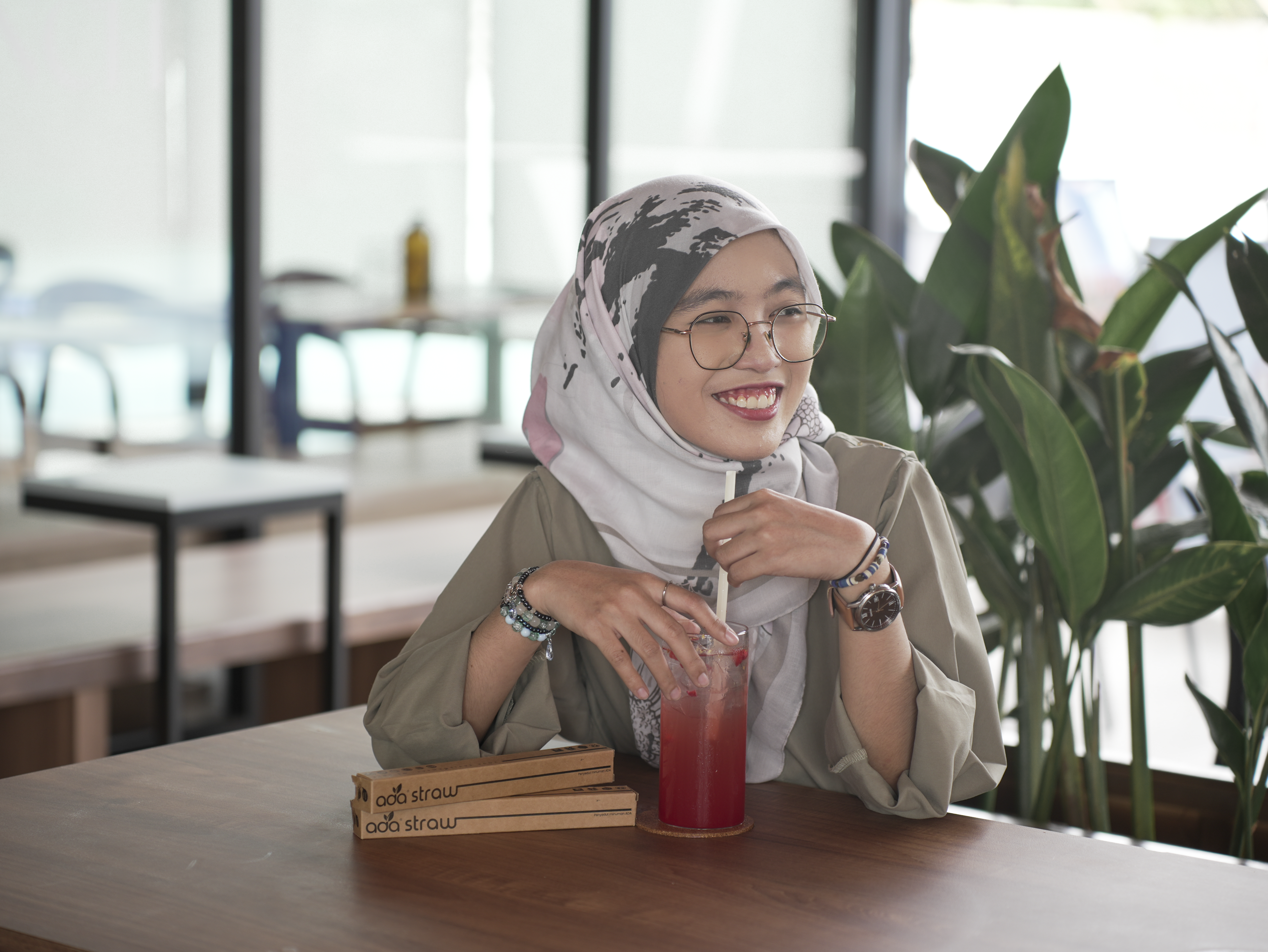 A cafe customer using an ADA straw with an iced drink